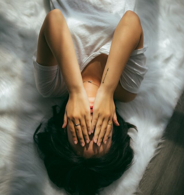 Woman upside down with hands over her eyes